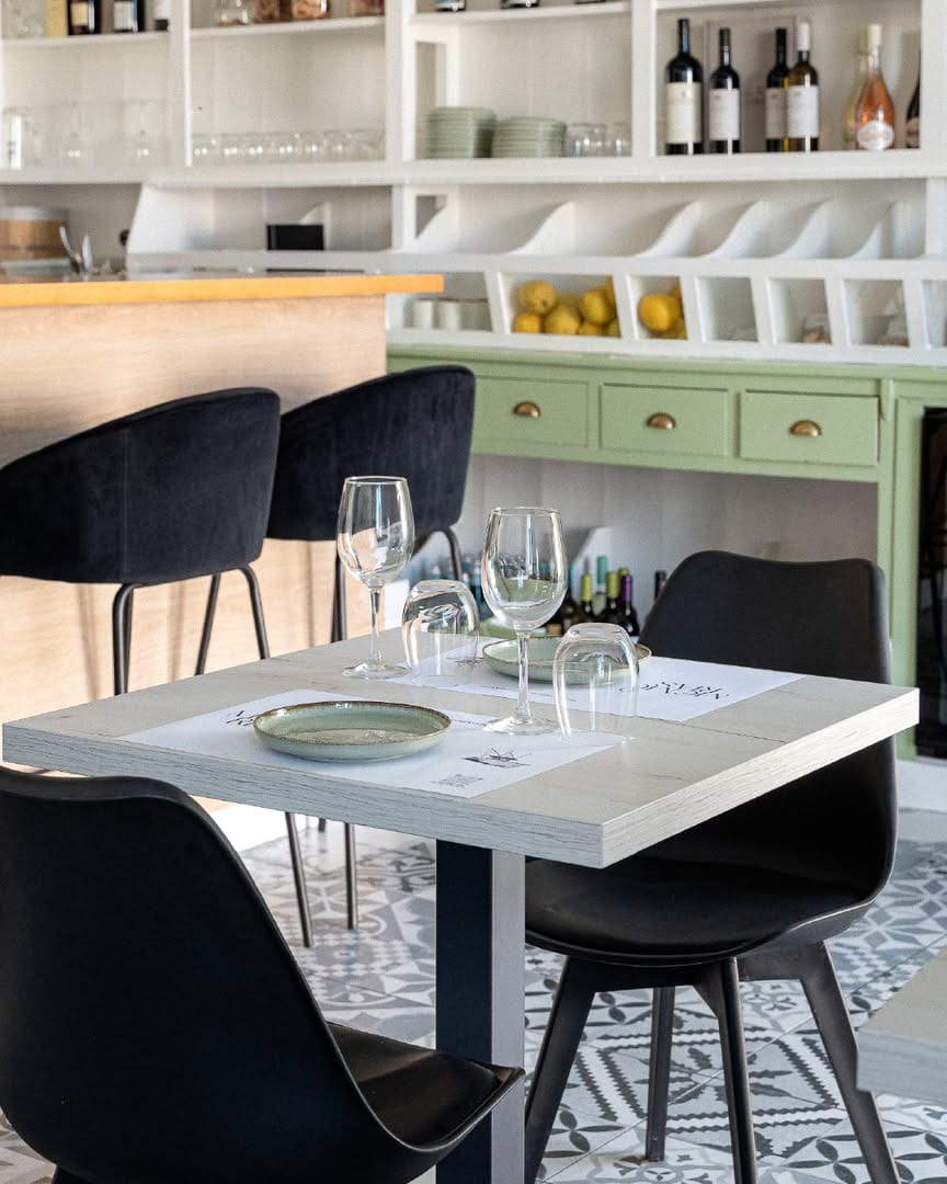 Interior: mesa posta, louça verde e azulejo